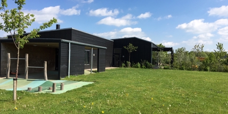 På billedet ser du en del af daginstitutionens bygning i Lund Børnehus og et legeområde